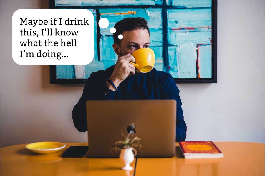 Man sips a cup of coffee at a laptop with the caption, "Maybe if I drink this, I'll know what the hell I'm doing..."