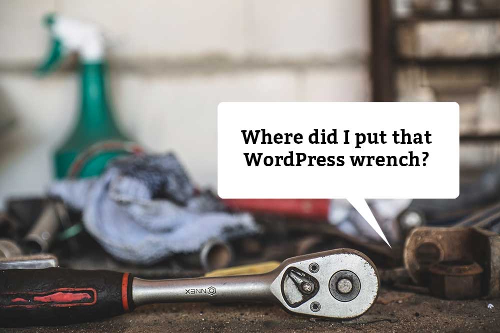 Workbench with dirty rags and tools. Caption balloon says, "Where did I put that WordPress wrench?"